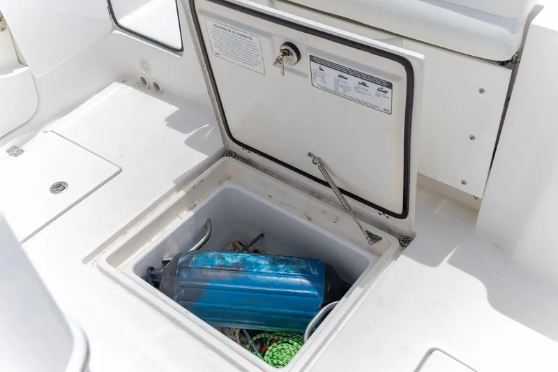 Slide: The Image of 2023 Edgewater 262CC boat storage compartment with blue fender and rope. - 32