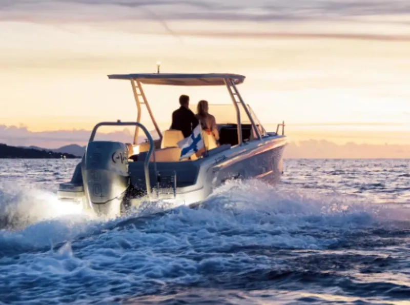 Slide: The Image of 2025 Axopar AX/E 25 boat cruising at sunset with passengers. - 4