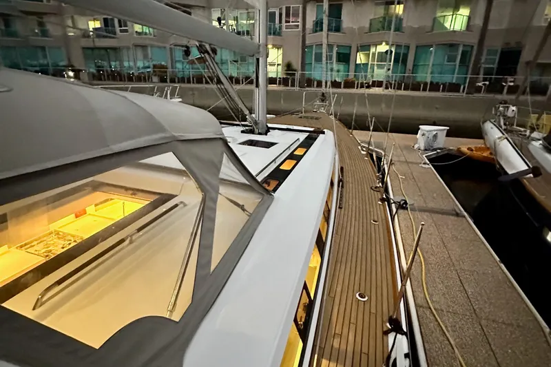 Slide: The Image of Beneteau Oceanis 55.1 yacht docked, showcasing sleek design and illuminated interior, 2021 model. - 10