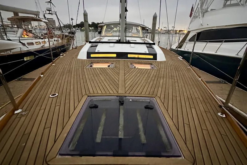 Slide: The Image of 2021 Beneteau Oceanis 55.1 yacht deck with sleek wooden finish, docked at marina. - 15
