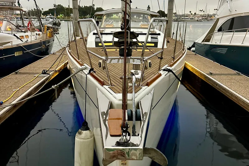 Slide: The Image of 2021 Beneteau Oceanis 55.1 yacht docked at marina, showcasing sleek design and wooden deck. - 21