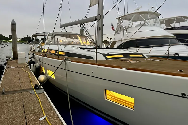 Slide: The Image of 2021 Beneteau Oceanis 55.1 yacht docked, illuminated windows, sleek design. - 23