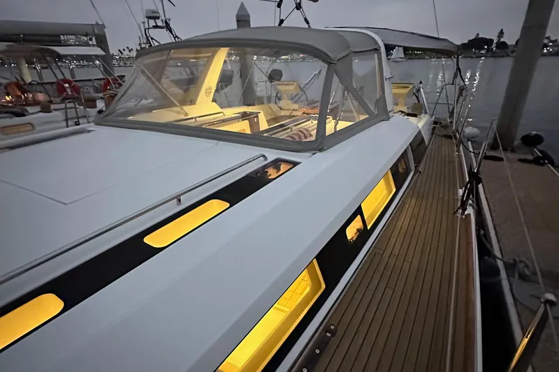 Slide: The Image of Beneteau Oceanis 55.1 yacht, 2021 model, docked at marina with illuminated interior. - 25