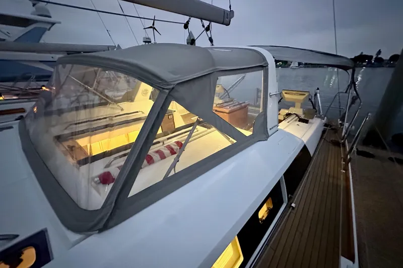 Slide: The Image of 2021 Beneteau Oceanis 55.1 yacht with illuminated interior, docked at twilight. - 26