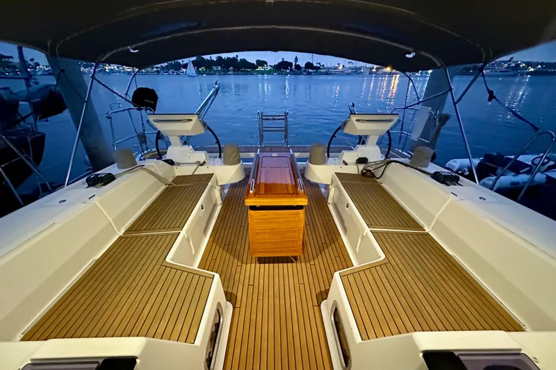 Slide: The Image of Luxurious 2021 Beneteau Oceanis 55.1 yacht deck at dusk, overlooking serene waters. - 28