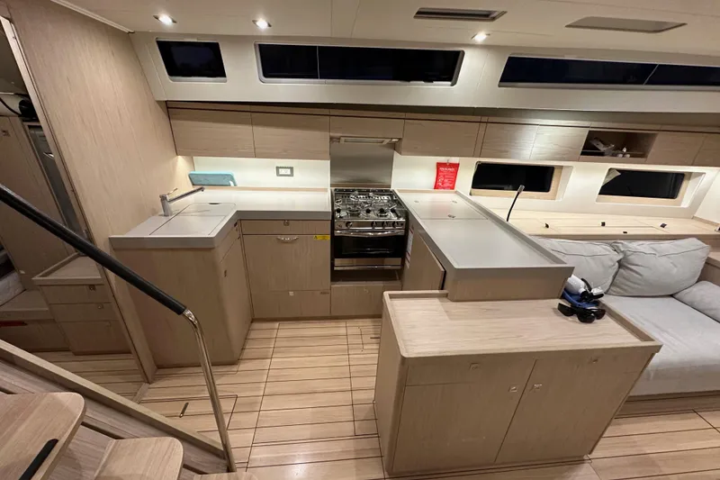 Slide: The Image of Interior of 2021 Beneteau Oceanis 55.1 yacht, featuring modern kitchen and seating area. - 43