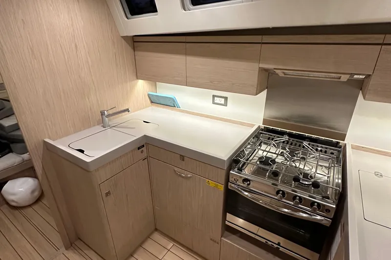 Slide: The Image of Modern kitchen in 2021 Beneteau Oceanis 55.1 yacht with stove and sleek cabinetry. - 45
