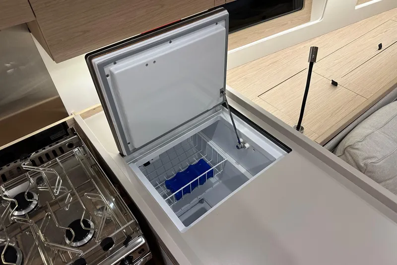 Slide: The Image of Interior of 2021 Beneteau Oceanis 55.1 yacht showing open freezer and stove. - 48