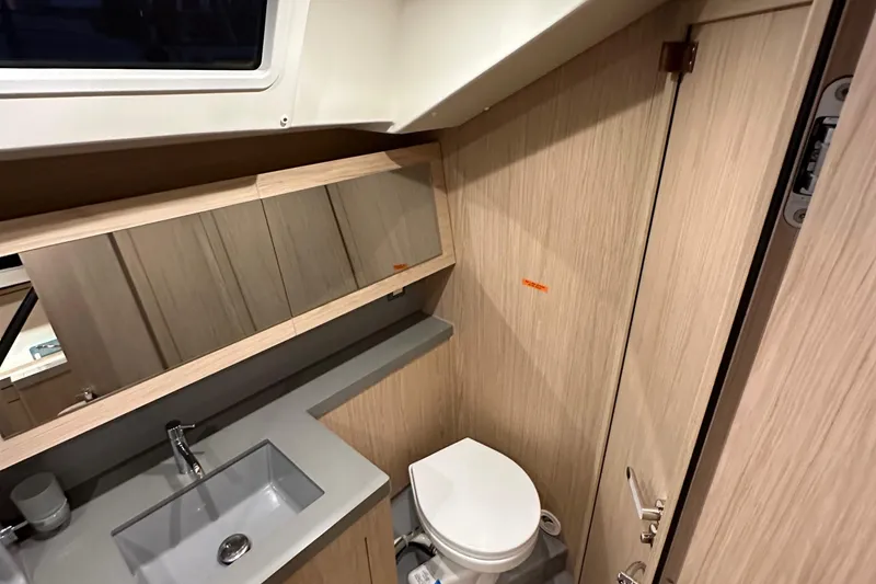 Slide: The Image of Modern bathroom in 2021 Beneteau Oceanis 55.1 yacht with sleek fixtures and wood finish. - 58