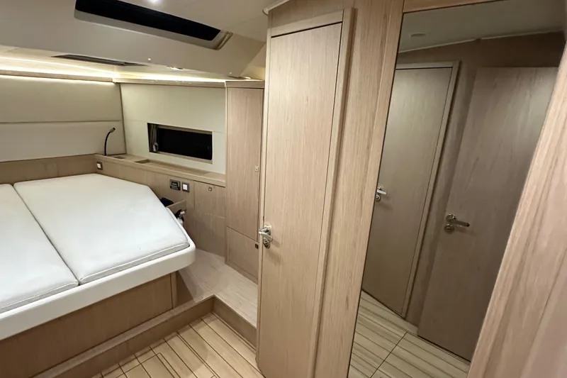 Slide: The Image of Interior of 2021 Beneteau Oceanis 55.1 yacht, featuring a modern bedroom with wood finishes. - 78