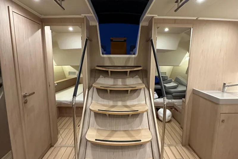 Slide: The Image of Interior of 2021 Beneteau Oceanis 55.1 yacht, featuring modern wooden stairs and cozy cabins. - 88
