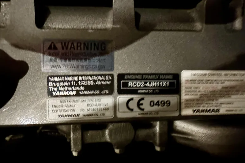 Slide: The Image of Yanmar engine label on a 2021 Beneteau Oceanis 55.1 sailboat, showing warning and certification details. - 93