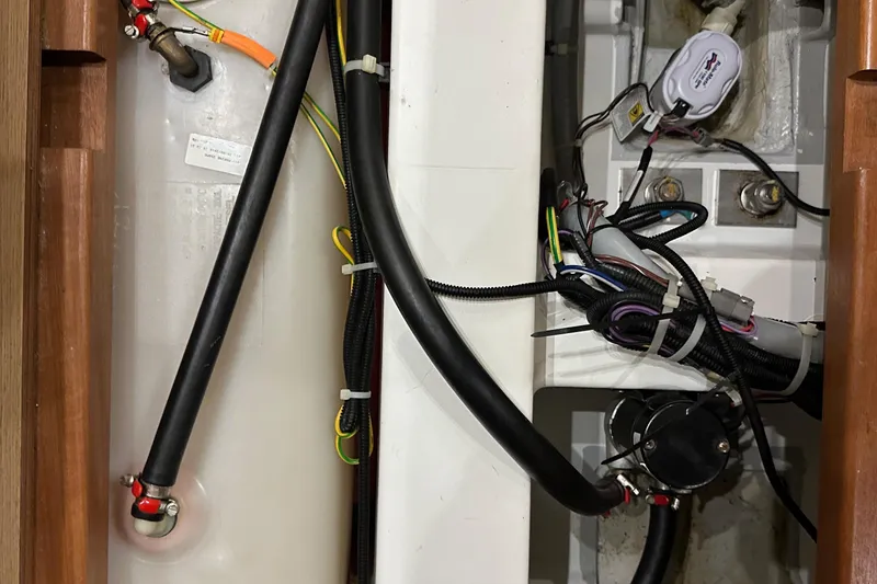 Slide: The Image of Engine compartment of a 2021 Beneteau Oceanis 55.1 yacht, showcasing wiring and hoses. - 95