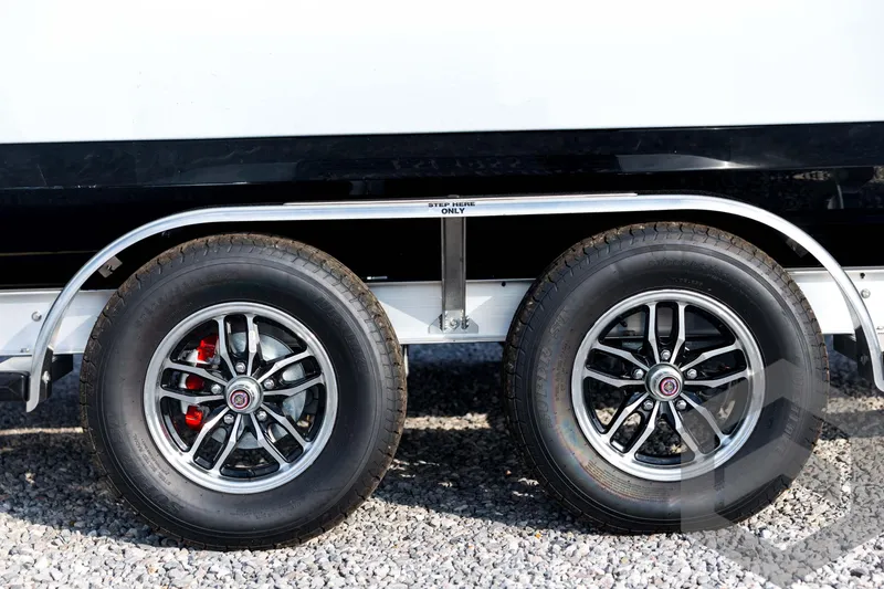 Slide: The Image of 2026 Tidewater 2410 Bay Max trailer wheels on gravel surface. - 12