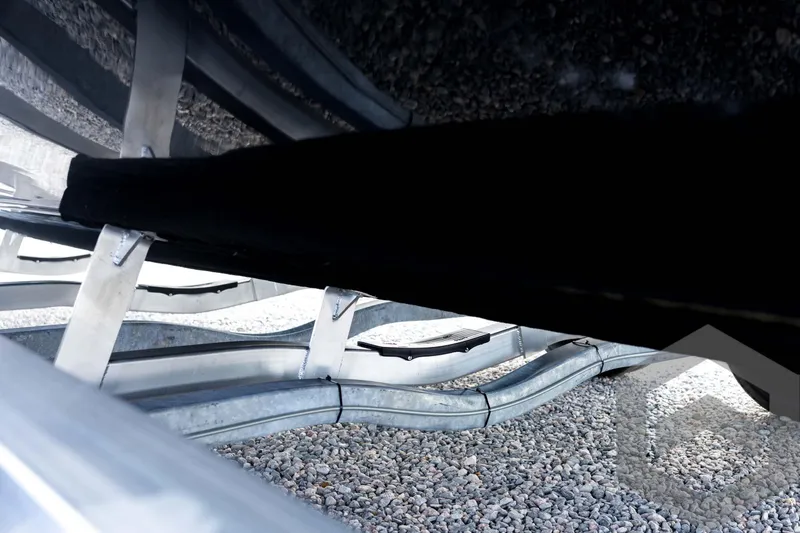 Slide: The Image of Underneath view of 2026 Tidewater 2410 Bay Max boat on a trailer with gravel ground. - 29