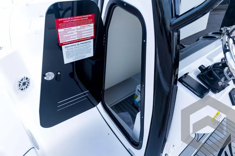 Slide: The Image of 2026 Tidewater 2410 Bay Max boat interior with open storage compartment and safety notices. - 48
