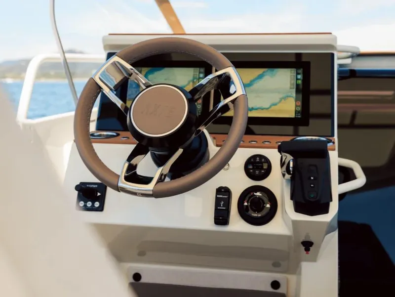 Slide: The Image of Steering wheel and dashboard of 2025 Axopar AX/E 25 boat with navigation display. - 6