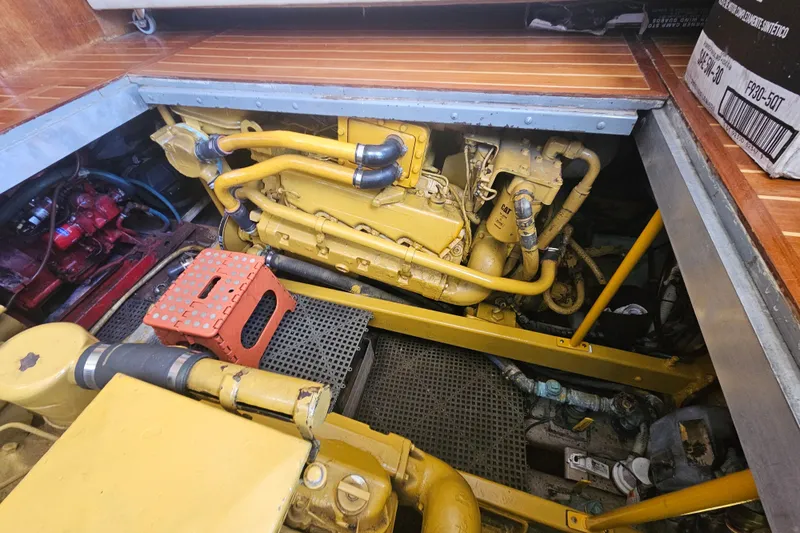 Slide: The Image of Engine compartment of a 1986 Viking 35 Convertible boat, featuring a yellow engine. - 12