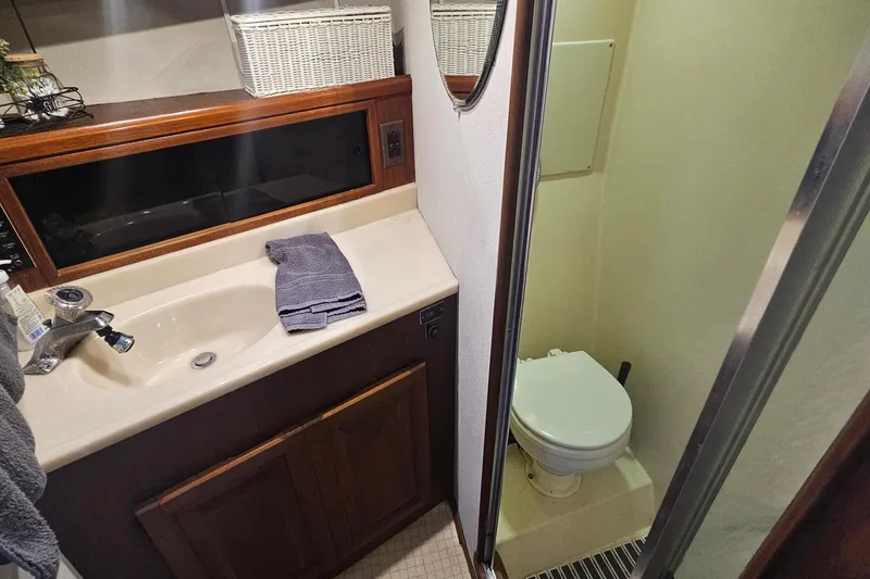 Slide: The Image of 1986 Viking 35 Convertible yacht bathroom with sink, toilet, and wooden cabinetry. - 9