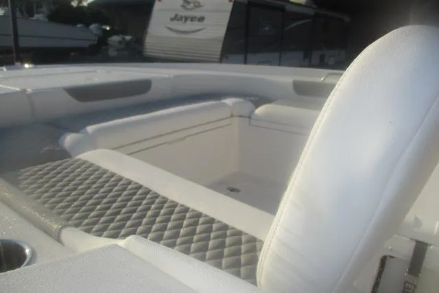 Slide: The Image of 2026 Caymas 24 HB boat interior with white cushioned seating and diamond-patterned upholstery. - 6