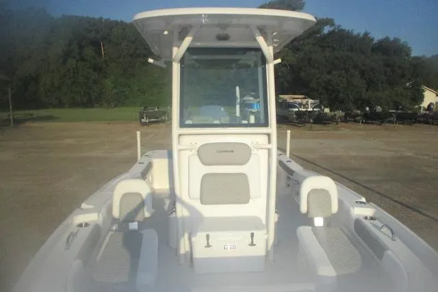 Slide: The Image of 2026 Caymas 24 HB boat with center console and seating, parked outdoors. - 7