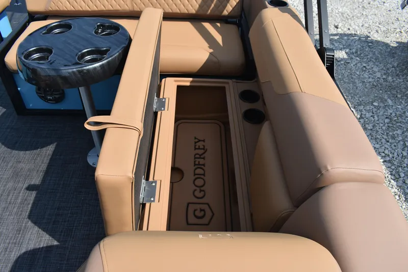 Slide: The Image of 2026 Godfrey SWEETWATER 2286 SFL boat interior with tan seating and cup holders. - 13