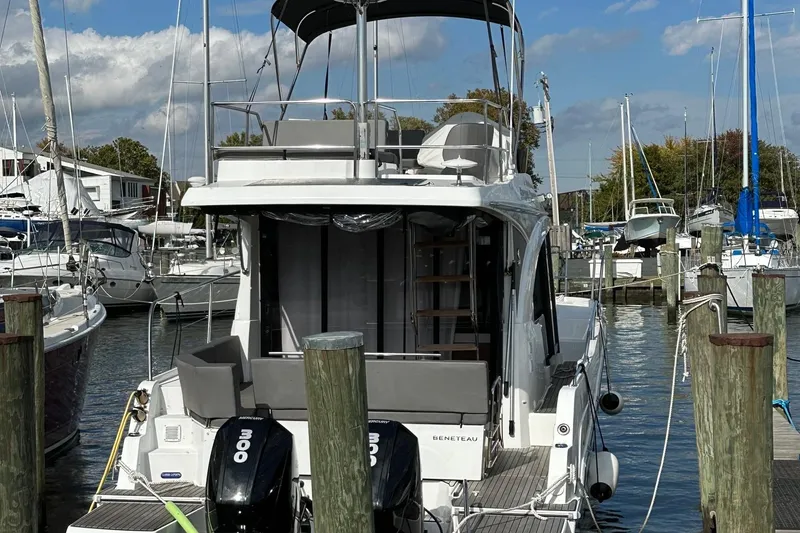 Slide: The Image of 2022 Beneteau Antares 11 Fly yacht docked at marina with twin outboard engines. - 2