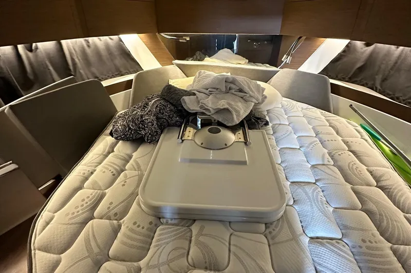Slide: The Image of Interior cabin of 2022 Beneteau Antares 11 Fly with bed and folded clothes. - 6