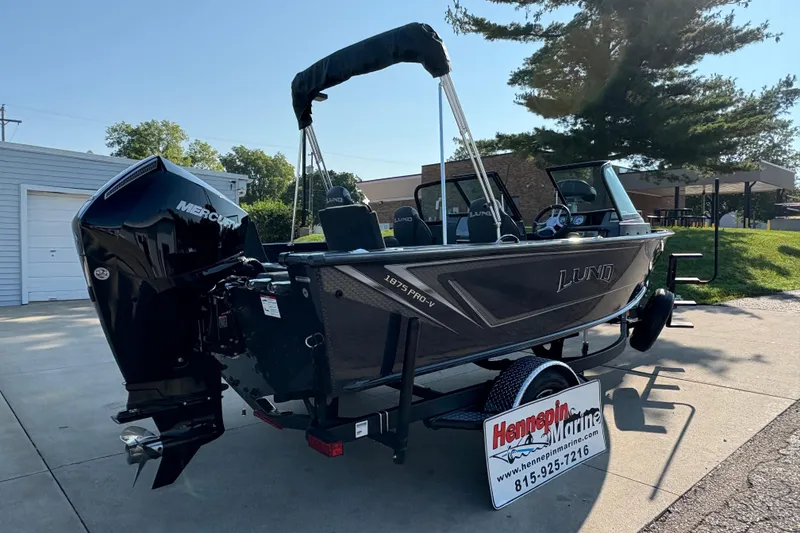 Slide: The Image of 2026 Lund 1875 Pro-V Sport boat with Mercury engine on trailer, outdoor setting. - 1