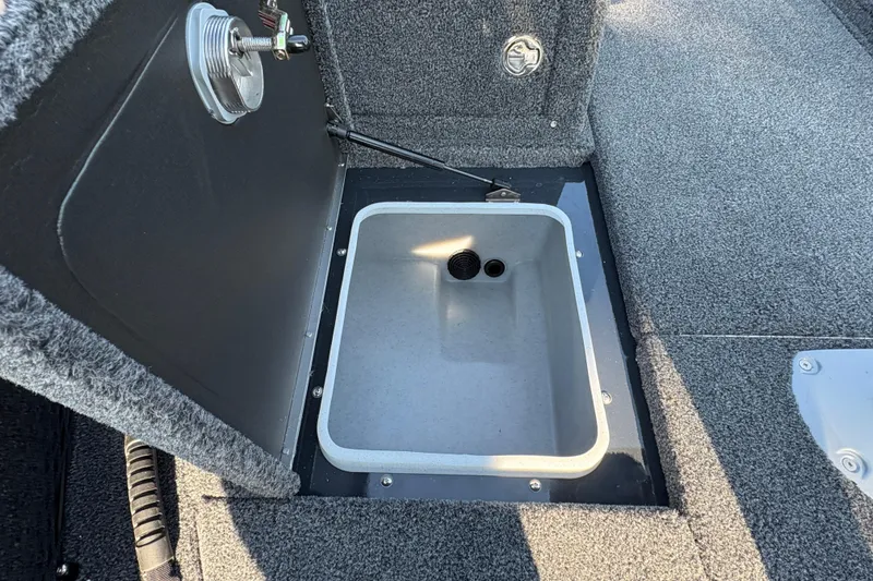 Slide: The Image of Open storage compartment in 2026 Lund 1875 Pro-V Sport boat, featuring gray interior. - 11