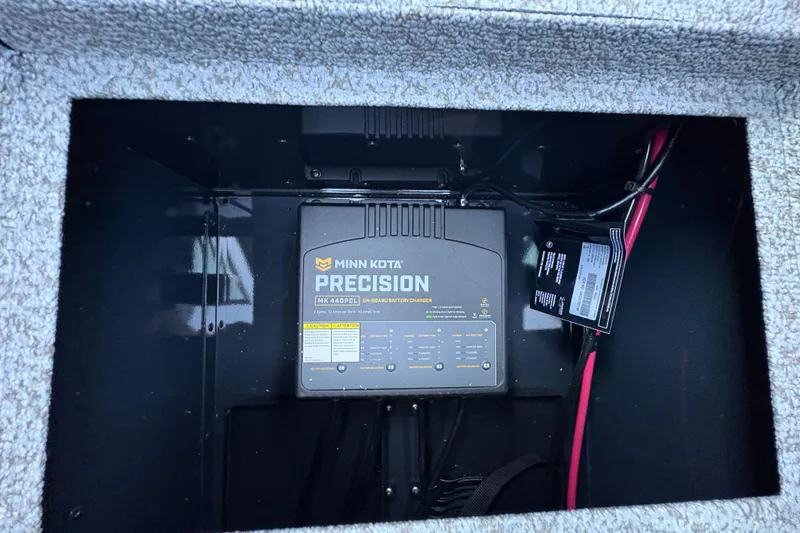 Slide: The Image of Minn Kota Precision battery charger in 2026 Lund 1875 Pro-V Sport boat compartment. - 17