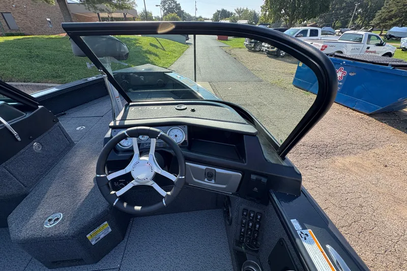 Slide: The Image of 2026 Lund 1875 Pro-V Sport boat interior with steering wheel and dashboard controls. - 23