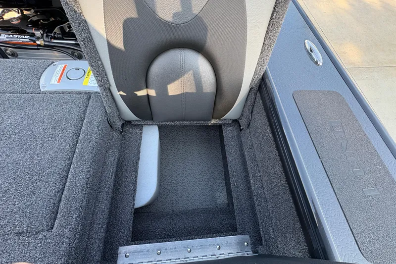 Slide: The Image of 2026 Lund 1875 Pro-V Sport boat interior with open storage compartment and seat detail. - 35