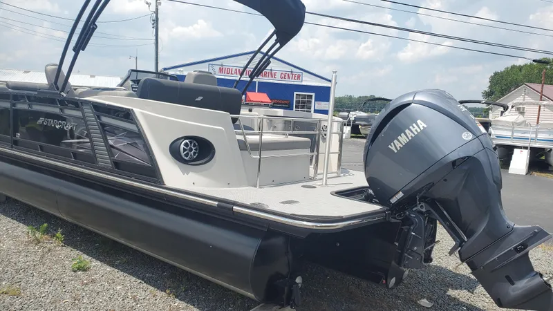 Slide: The Image of 2025 Starcraft MX 23 DL DH pontoon boat with Yamaha outboard motor at a marina. - 13