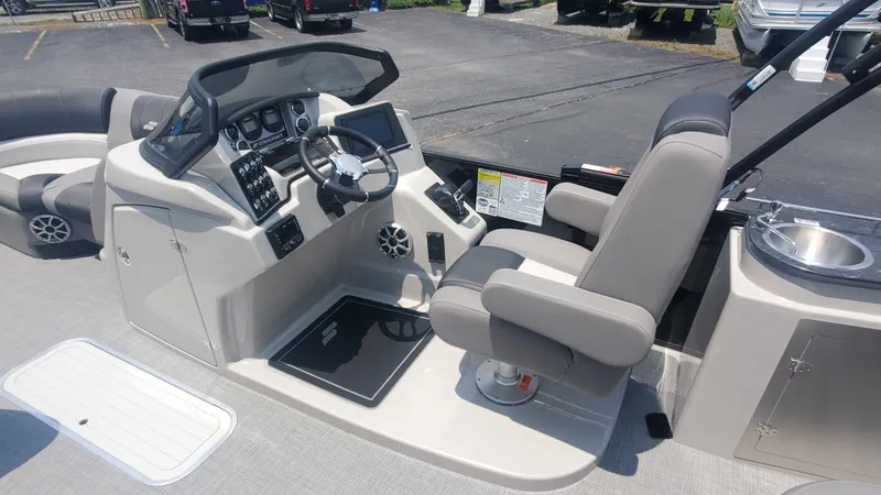 Slide: The Image of 2025 Starcraft MX 23 DL DH boat interior with helm, steering wheel, and seating. - 2
