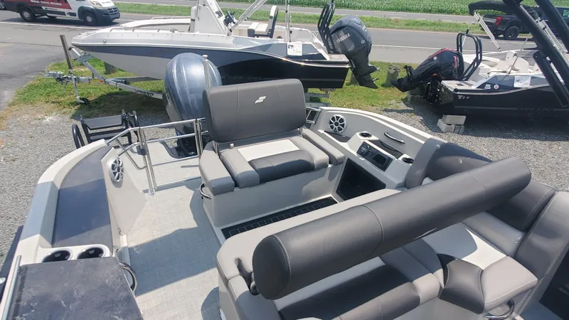 Slide: The Image of 2025 Starcraft MX 23 DL DH boat interior with seating and controls, displayed outdoors. - 9