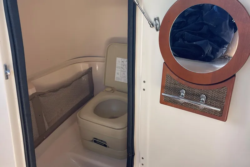 Slide: The Image of 2014 Grady-White Freedom 225 boat interior with toilet and mirror. - 15