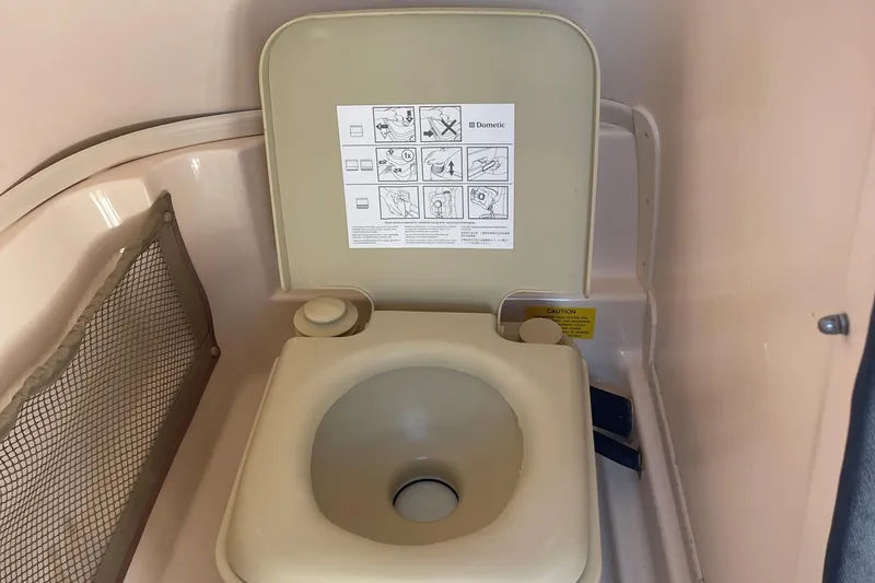 Slide: The Image of 2014 Grady-White Freedom 225 boat toilet with instruction label and storage net. - 16