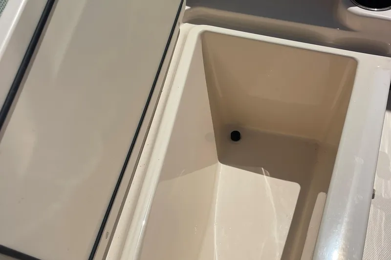 Slide: The Image of Storage compartment on a 2014 Grady-White Freedom 225 boat, featuring a clean, beige interior. - 18