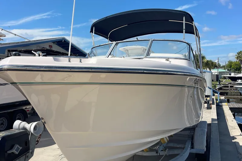 Slide: The Image of 2014 Grady-White Freedom 225 boat on trailer, docked under blue sky. - 3