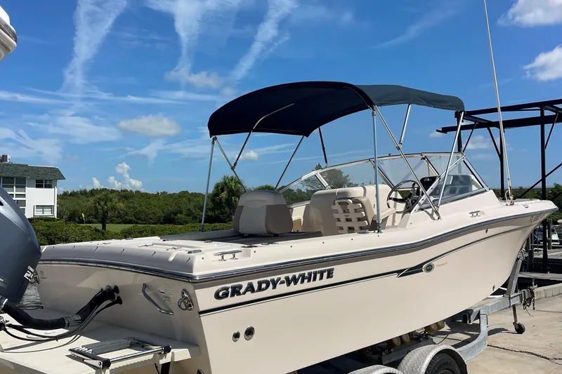 Slide: The Image of 2014 Grady-White Freedom 225 boat on trailer under clear blue sky. - 4