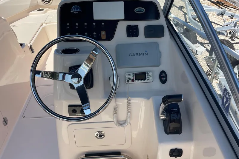 Slide: The Image of 2014 Grady-White Freedom 225 boat dashboard with Garmin navigation system and steering wheel. - 6