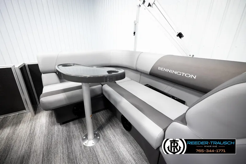 Slide: The Image of 2026 Bennington 168 SFSE boat interior with gray seating and table, Reeder-Trausch Marine logo. - 25
