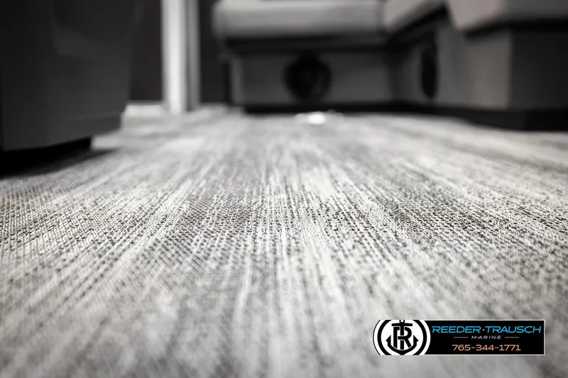 Slide: The Image of 2026 Bennington 168 SFSE interior flooring, textured gray carpet, Reeder-Trausch Marine logo visible. - 46