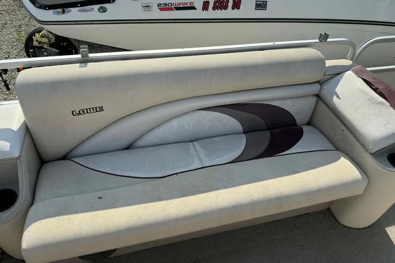 Slide: The Image of Lowe 240 Family 1997 boat seat with beige and maroon upholstery, featuring cup holders. - 10