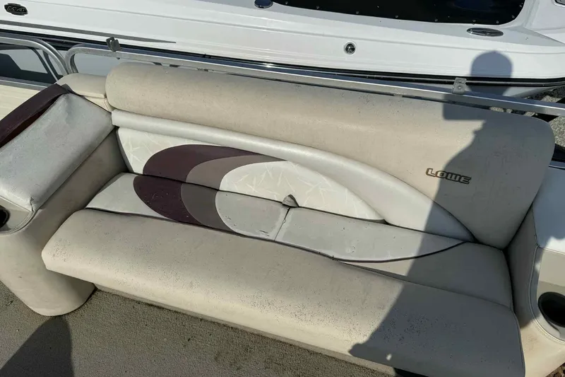 Slide: The Image of 1997 Lowe 240 Family boat seat with beige upholstery and circular design. - 11