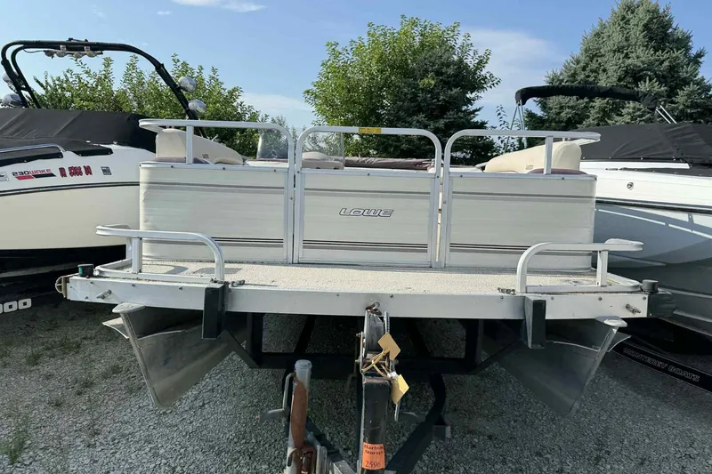 Slide: The Image of 1997 Lowe 240 Family pontoon boat on trailer, surrounded by trees and other boats. - 14