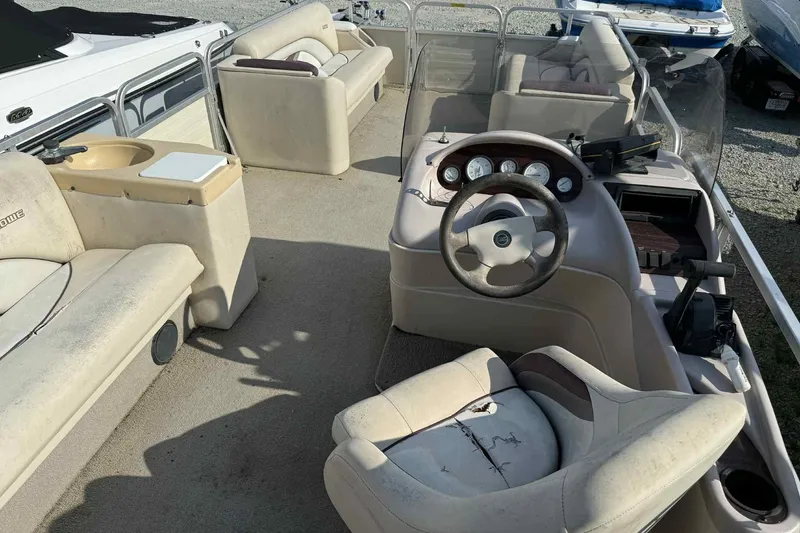 Slide: The Image of 1997 Lowe 240 Family boat interior with steering wheel and seating. - 4