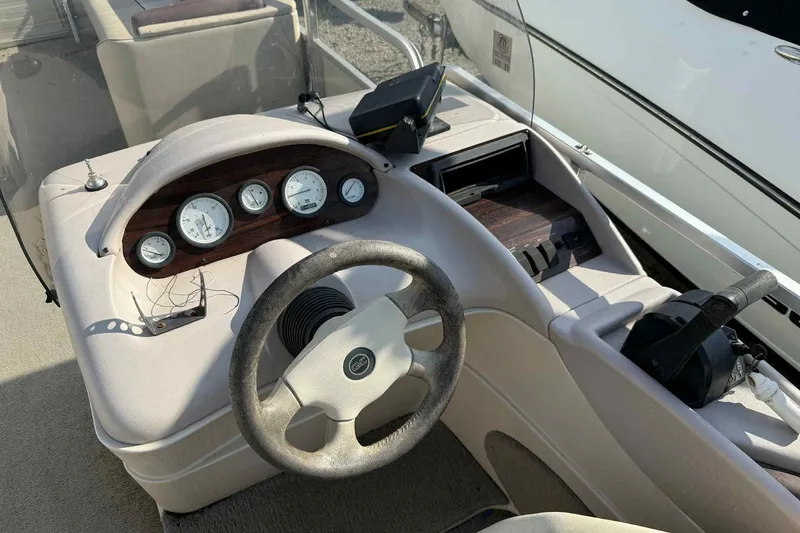 Slide: The Image of 1997 Lowe 240 Family boat dashboard with steering wheel and gauges. - 5