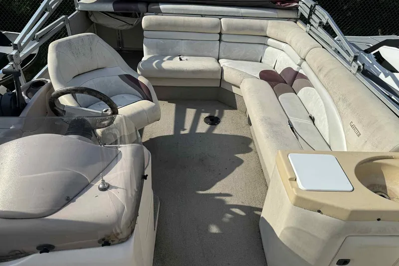 Slide: The Image of Interior of a 1997 Lowe 240 Family boat with beige seating and steering wheel. - 9